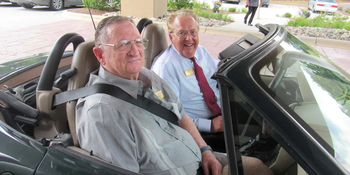 Seniors driving around in their convertible car 