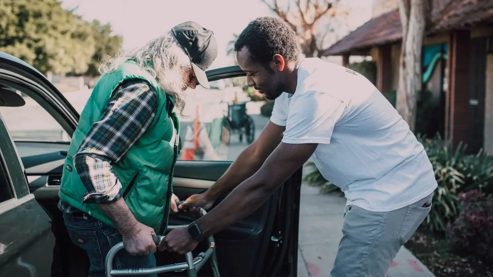 Man Assisting Person with Walker