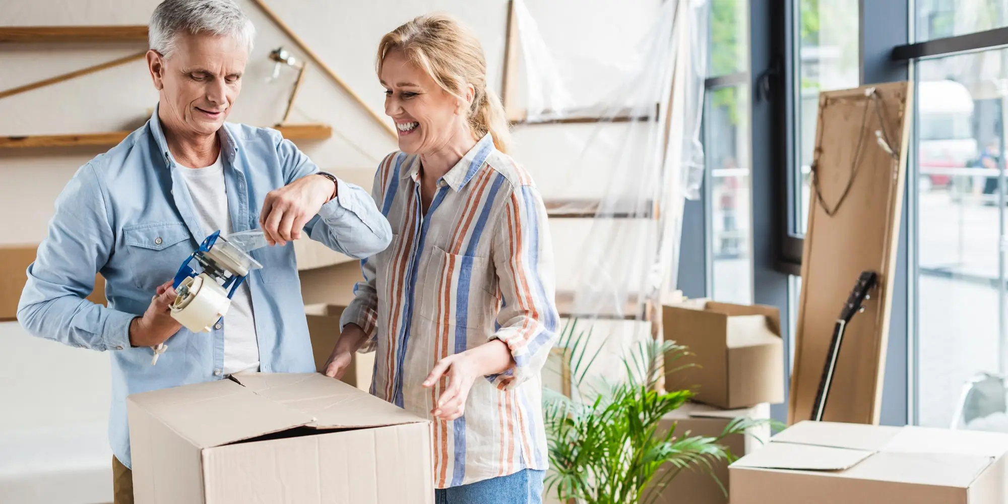 Senior couple packing their belongings to move out of the house.