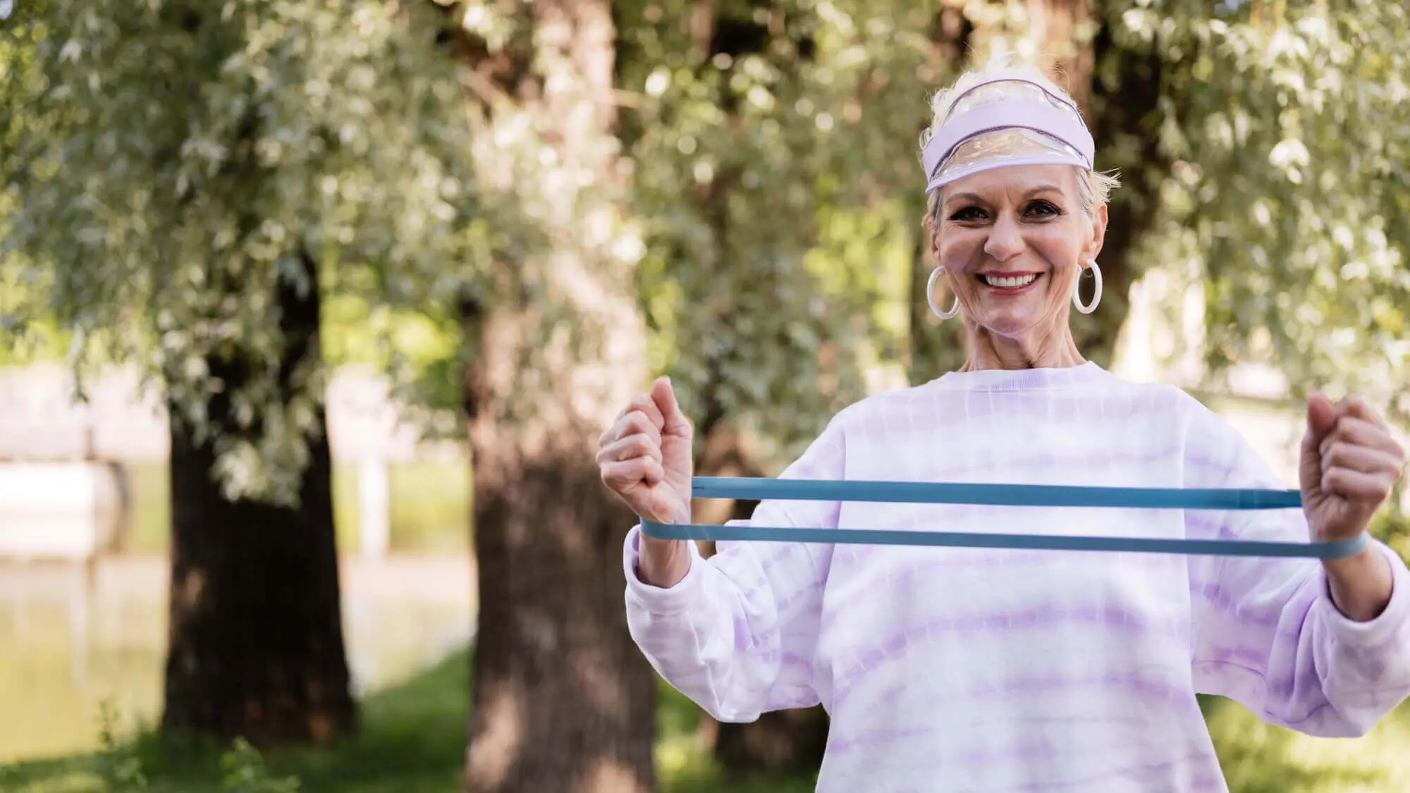 Woman in Purple and White Sweater Holding Blue Resistance Band