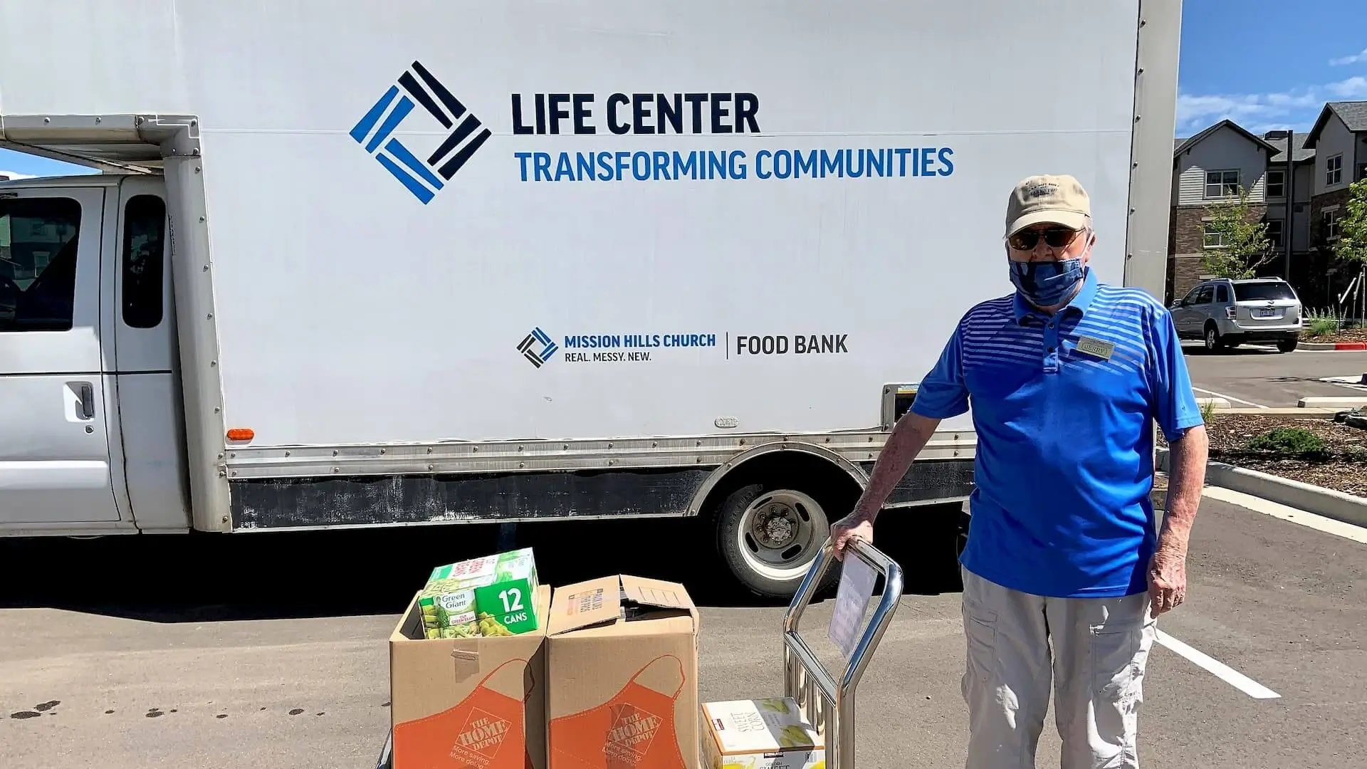 Sky Pointe resident posing with load of food for area food bank