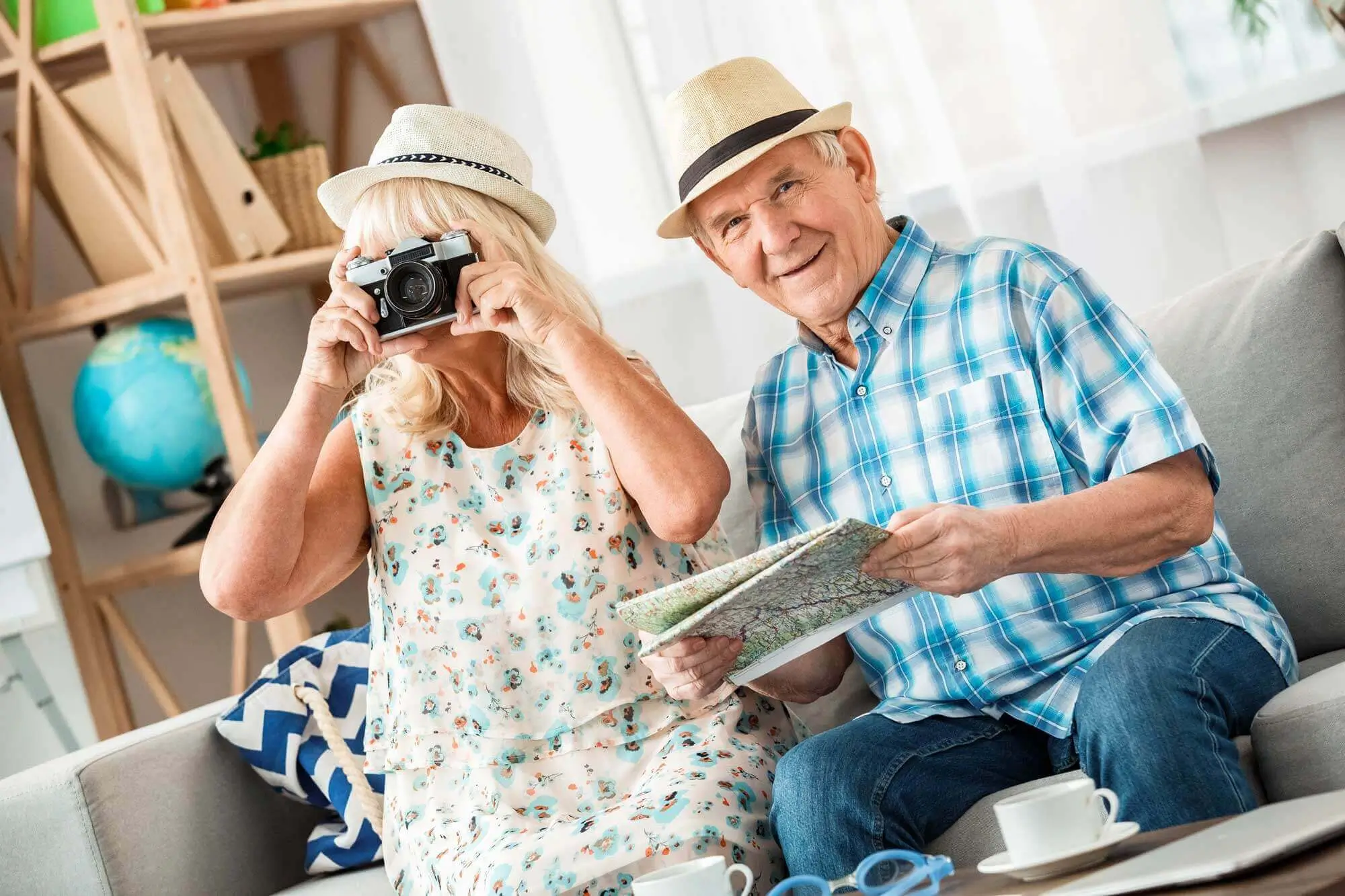 Woman takes photo with camera while husband smiles looking at a map