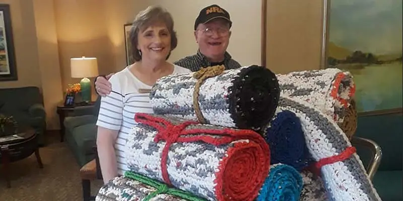 Happy seniors giving their quilts to others.