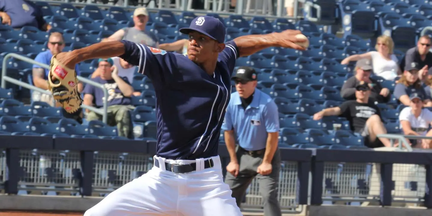 A San Diego baseball pitcher winding up to throw a pitch, while fans are watching the game.