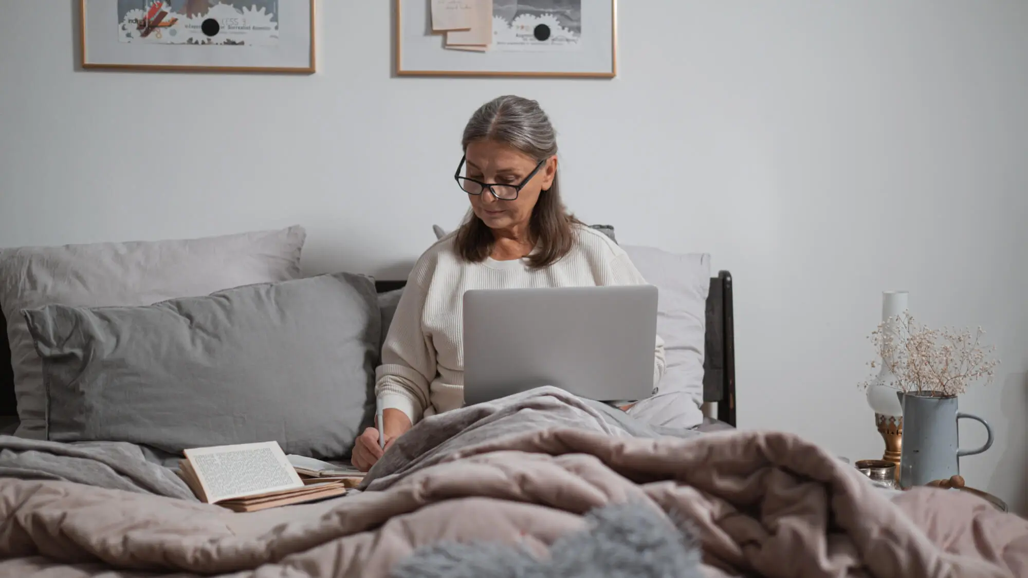 A Woman Using Laptop Sitting on the Bed