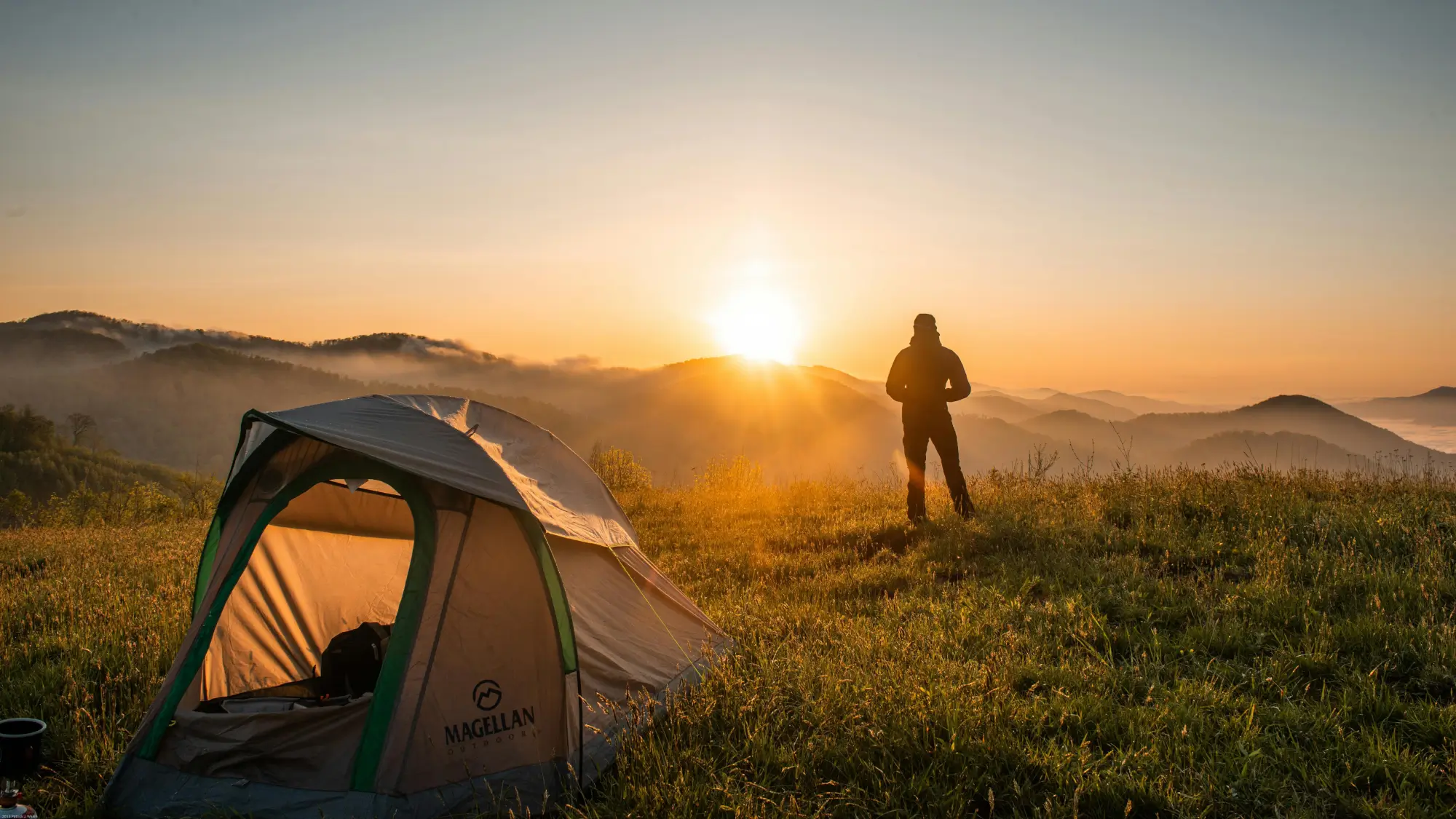 Silhouette of Person Standing Near Camping Tent