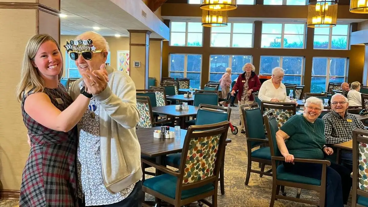 Kena Casaol, lifestyle director with Resort Lifestyle Communities, dances with World War II veteran and birthday boy Ed Rosen the day before he turns 100.