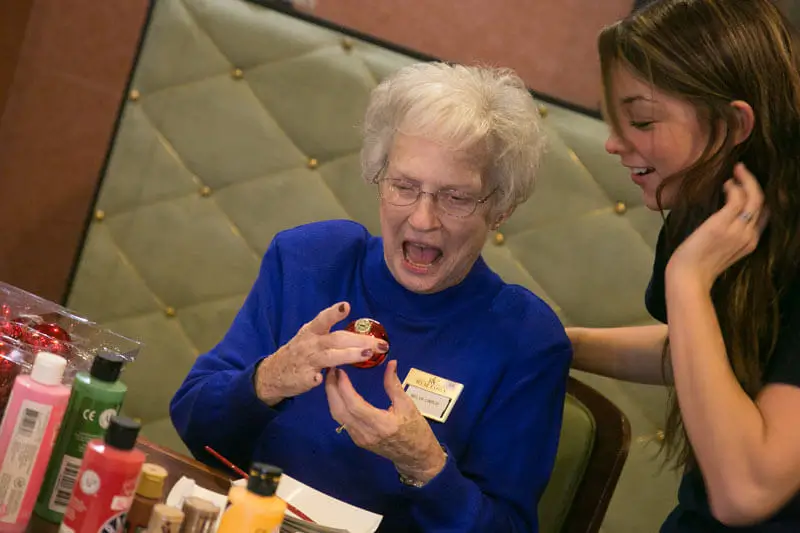 Senior and an employee of Resort Lifestyle Communities decorating ordainments.