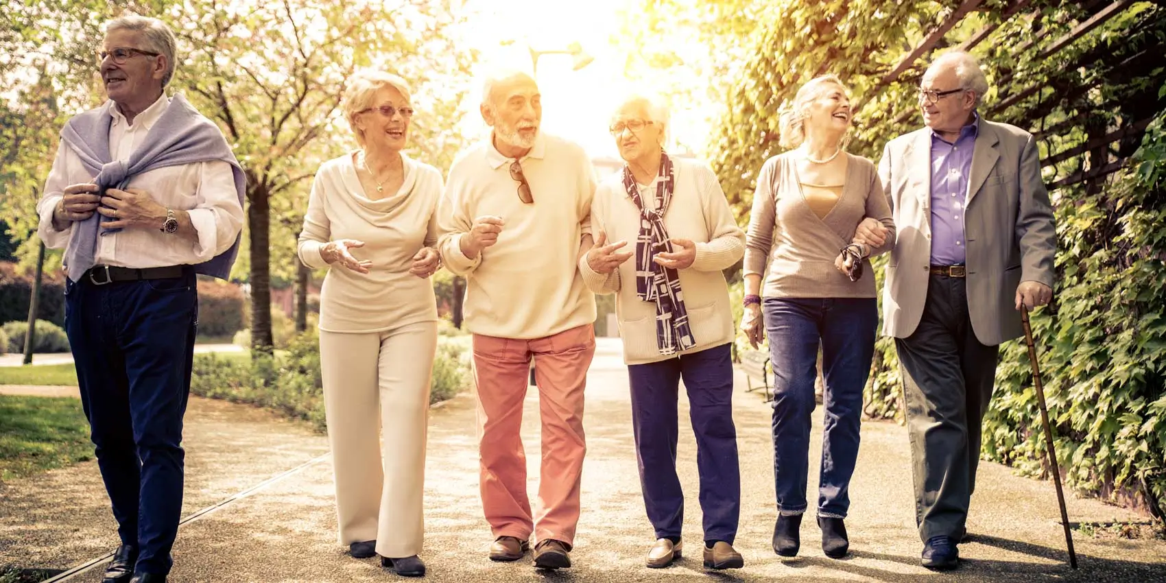 Happy senior couples walking together on a sidewalk.