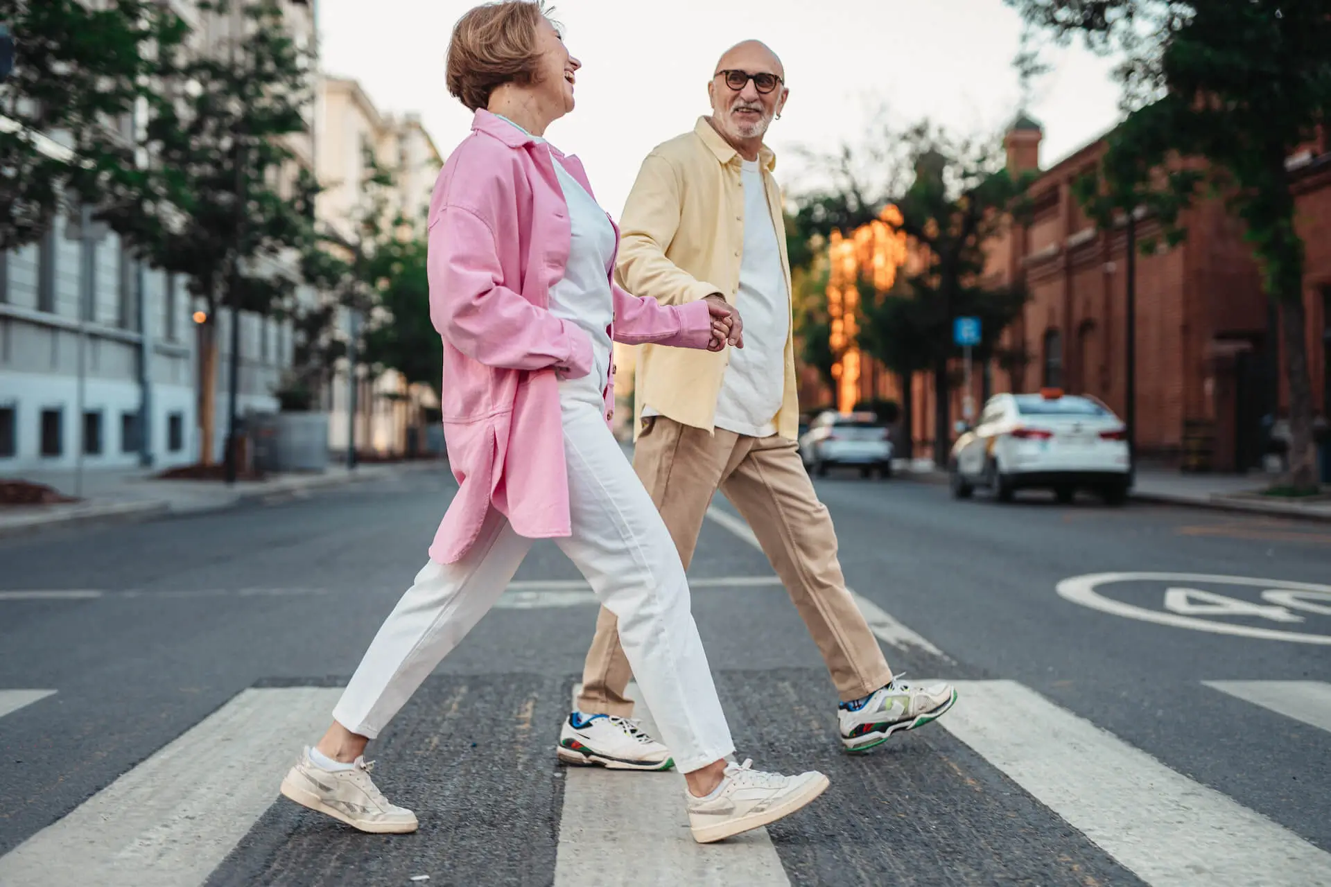 Happy Elderly Couple Holding Hands while Crossing on the Pedestrian Lane