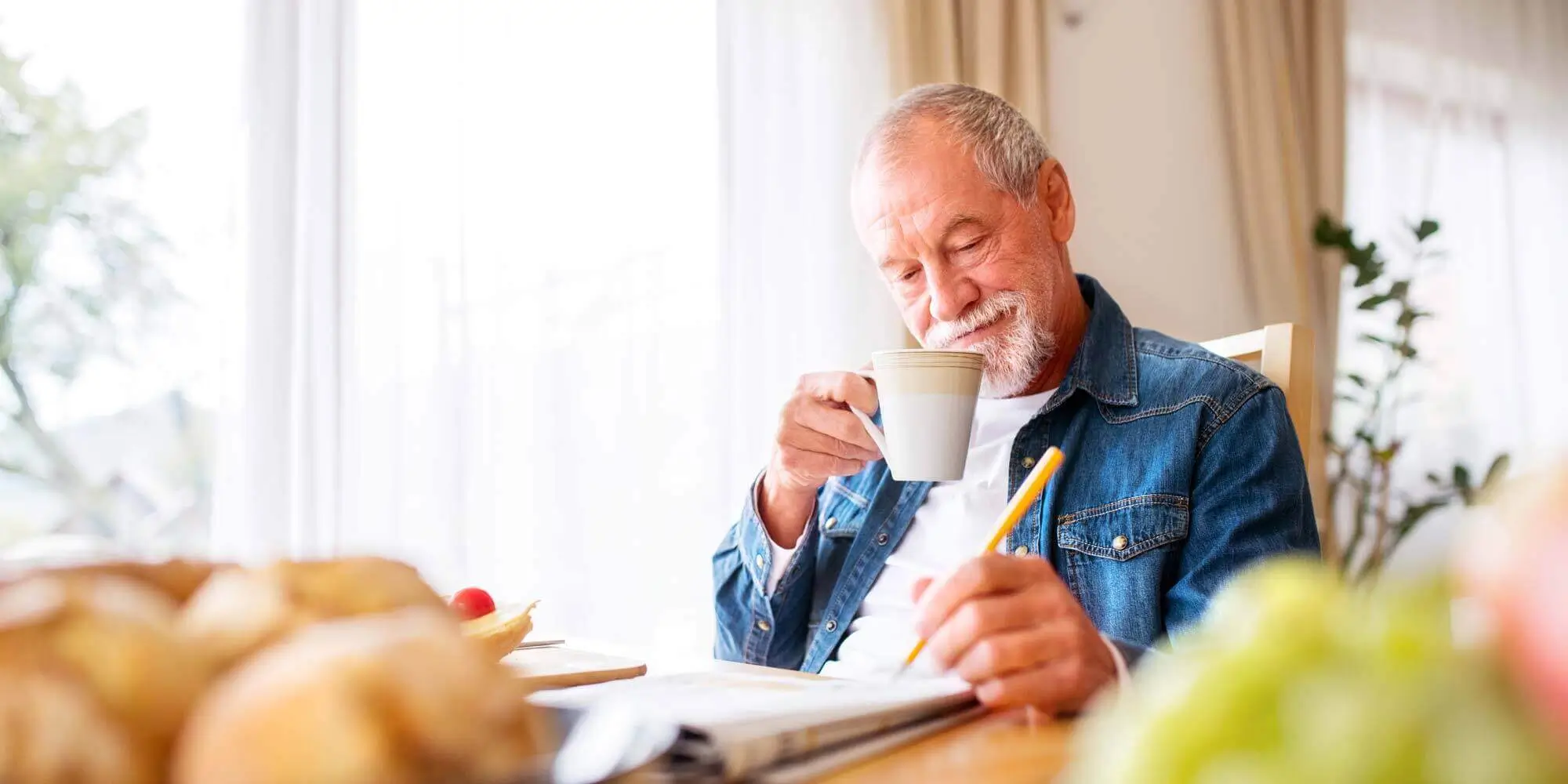 Resident enjoying a cup of coffee and a crossword puzzle.