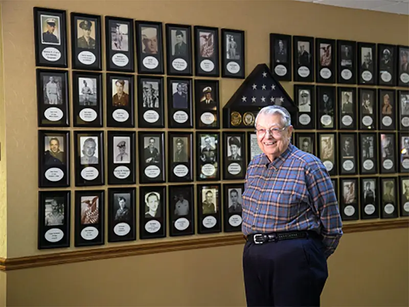 Senior standing in front of the Wall of Honor.