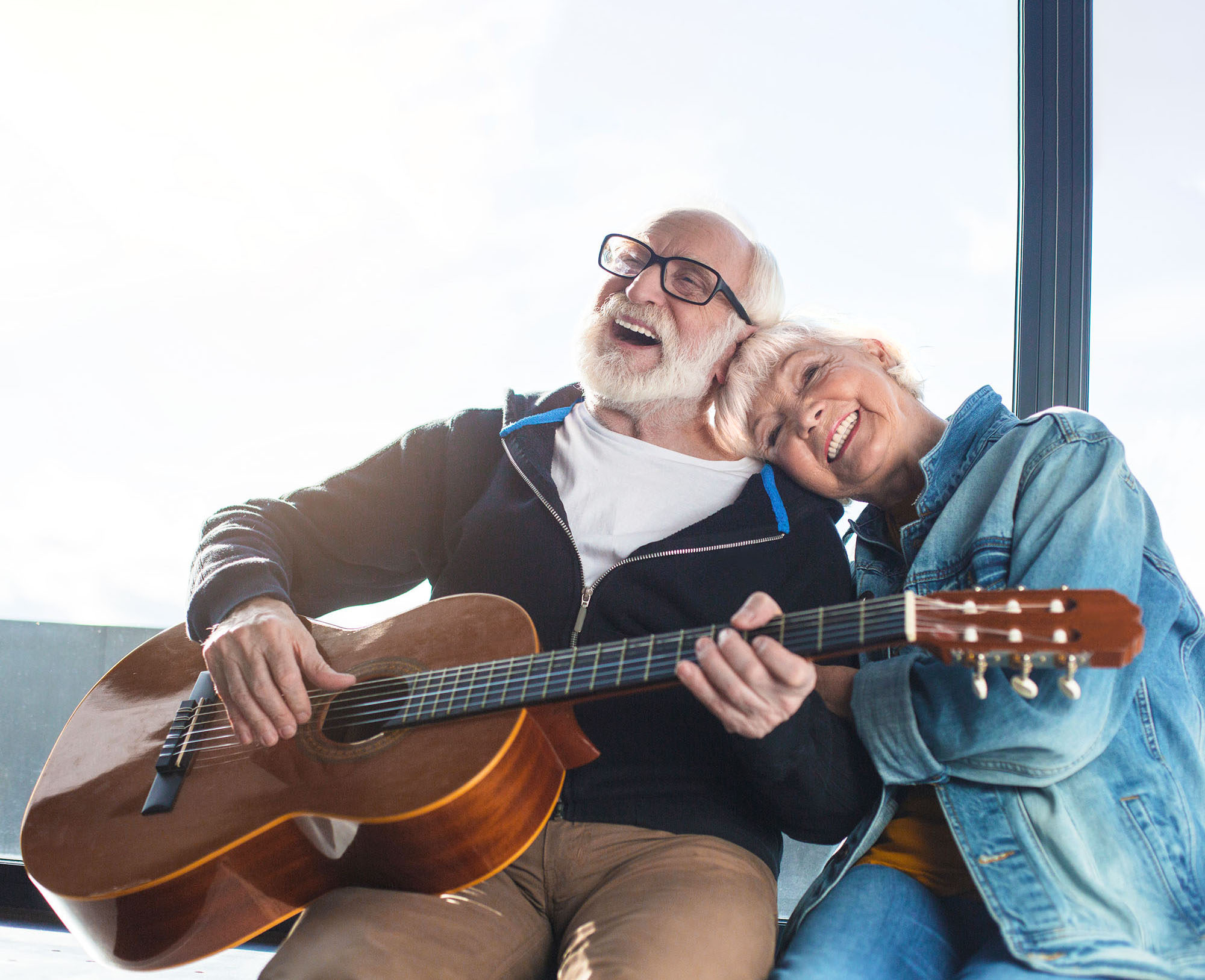 Happy senior couple playing guitar together and enjoying an active retirement lifestyle.