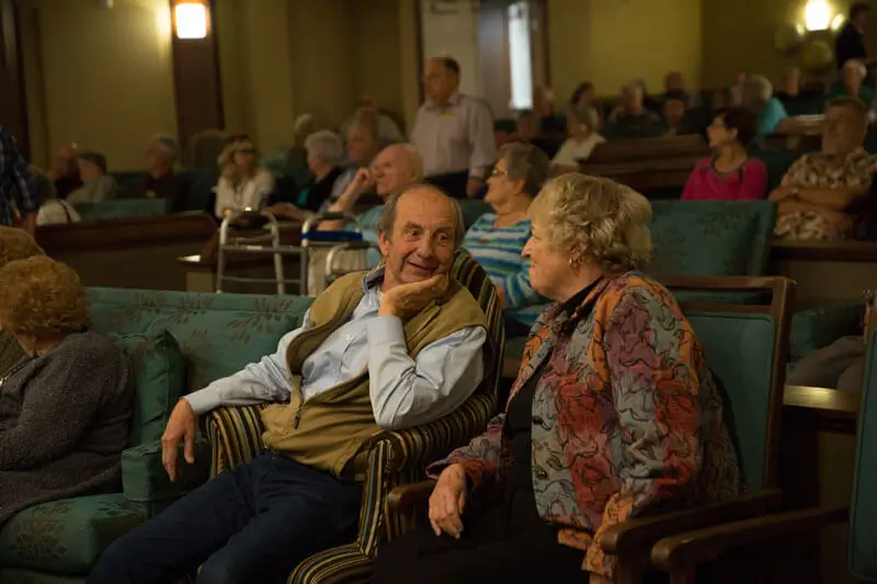 Seniors gathered together in a theatre to watch a movie.