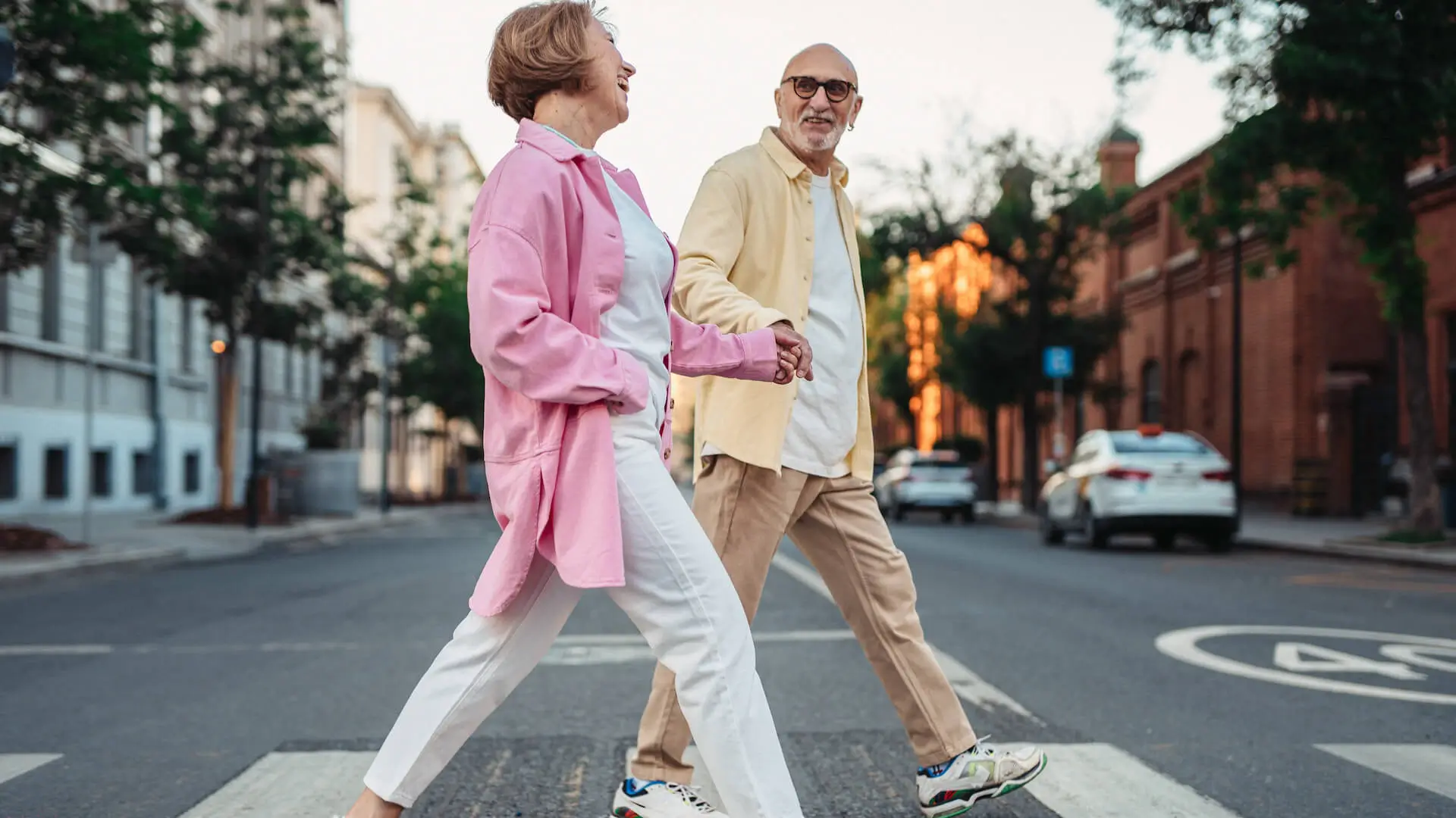 Happy Elderly Couple Holding Hands while Crossing on the Pedestrian Lane