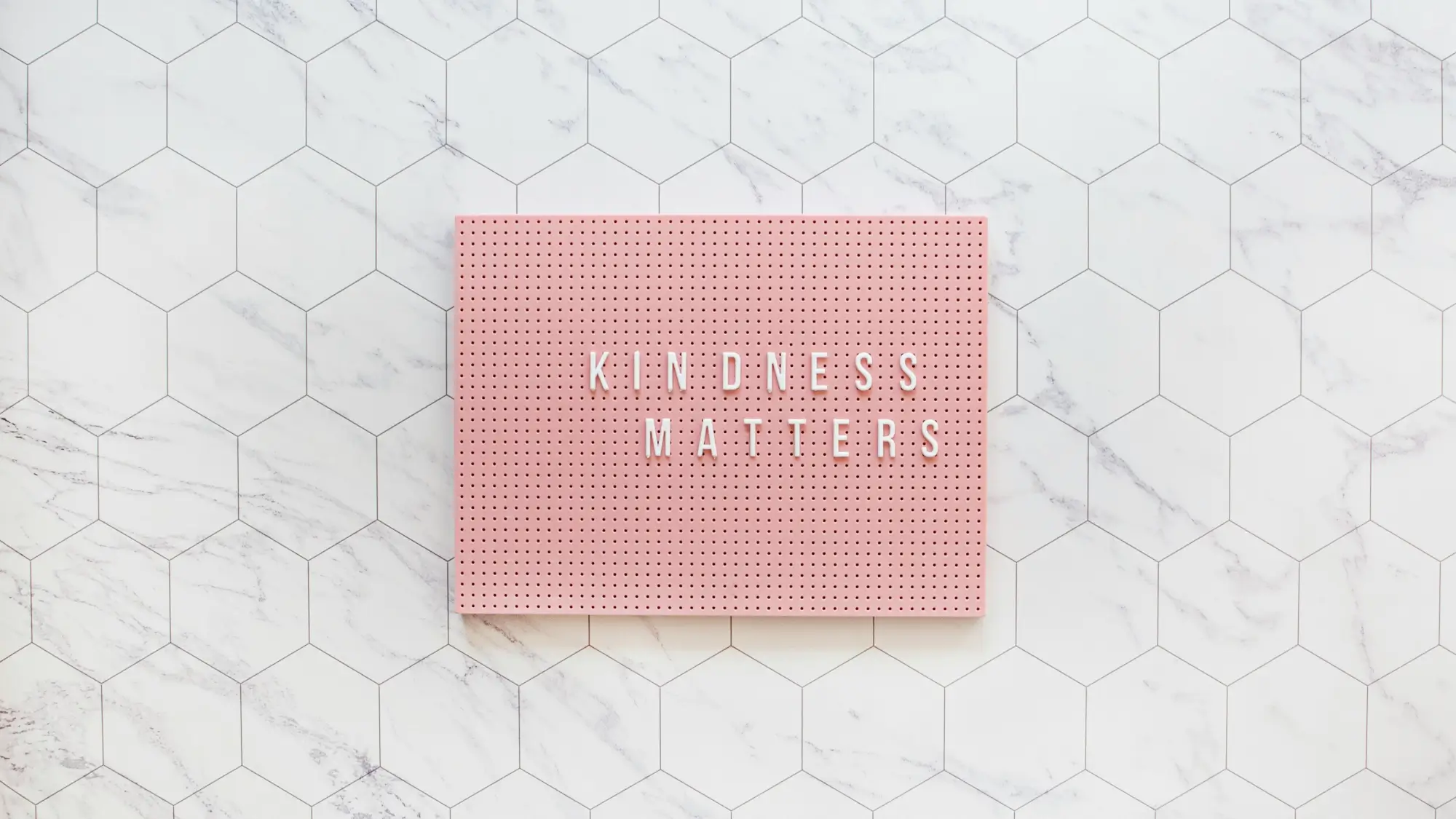 Kindness matters, be kind always. Pink pegboard on while tiles