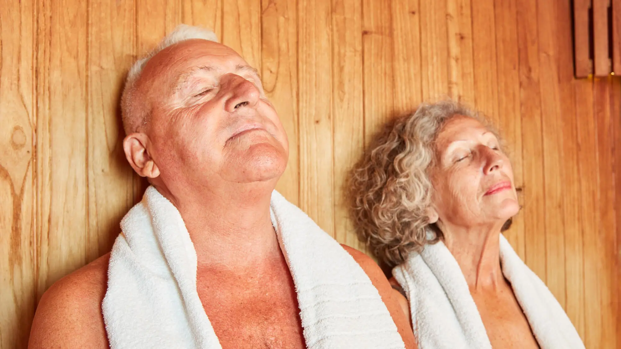 Relaxed senior couple enjoying the healthy heat in the wellness sauna
