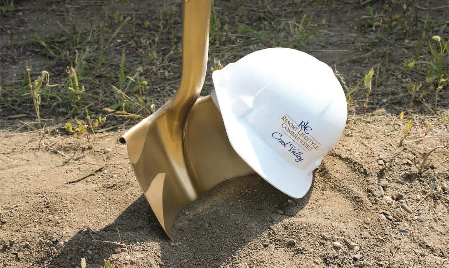 Golden shovel and Resort Lifestyle Communities hard hat to represent the construction being done at Creek Valley