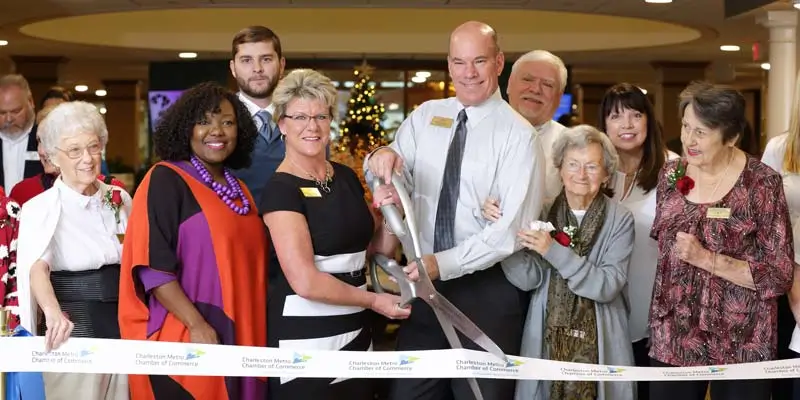 A group of seniors and managers celebrating the grand opening of a community within Resort Lifestyle Communities.