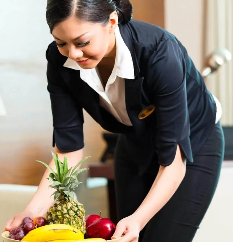 Housekeeper placing fruit in a residents room at Resort Lifestyle Communities.