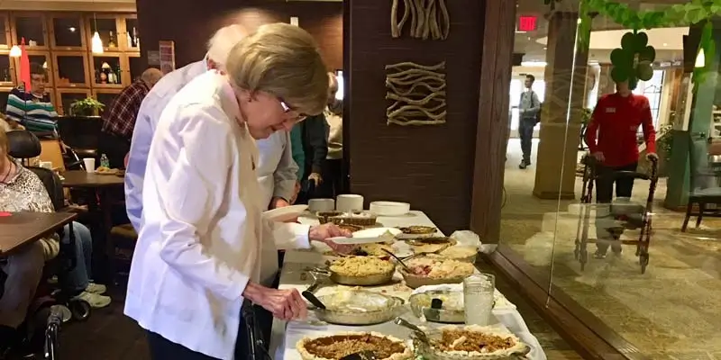 Seniors helping themselves to a piece of pie in the dining area of Resort Lifestyle Communities.