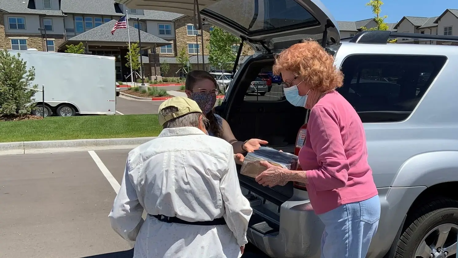 Seniors receiving groceries from a delivery girl.