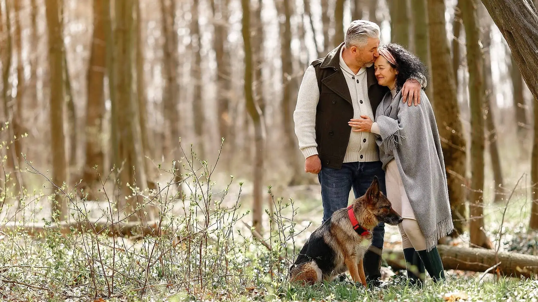 Senior couple spending time in the forest with their dog.
