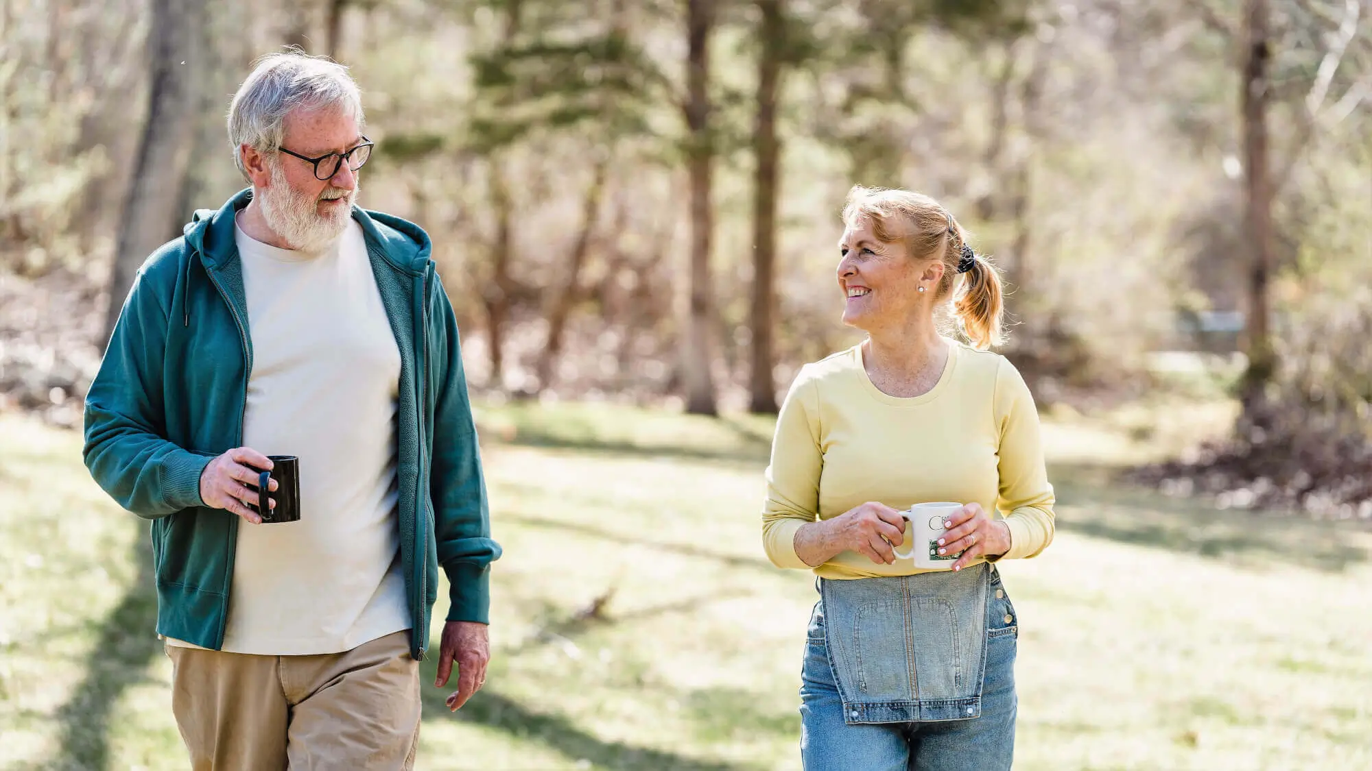 Elderly couple on a walk having a conversation with a cup of coffee in their hands