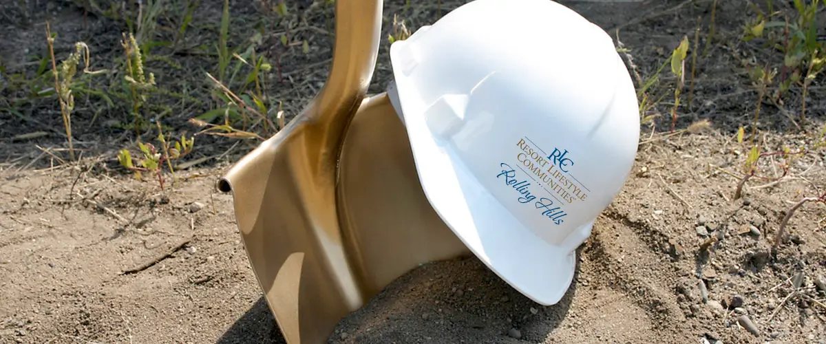 Golden shovel and Resort Lifestyle Communities hard hat representing Rolling Hills construction