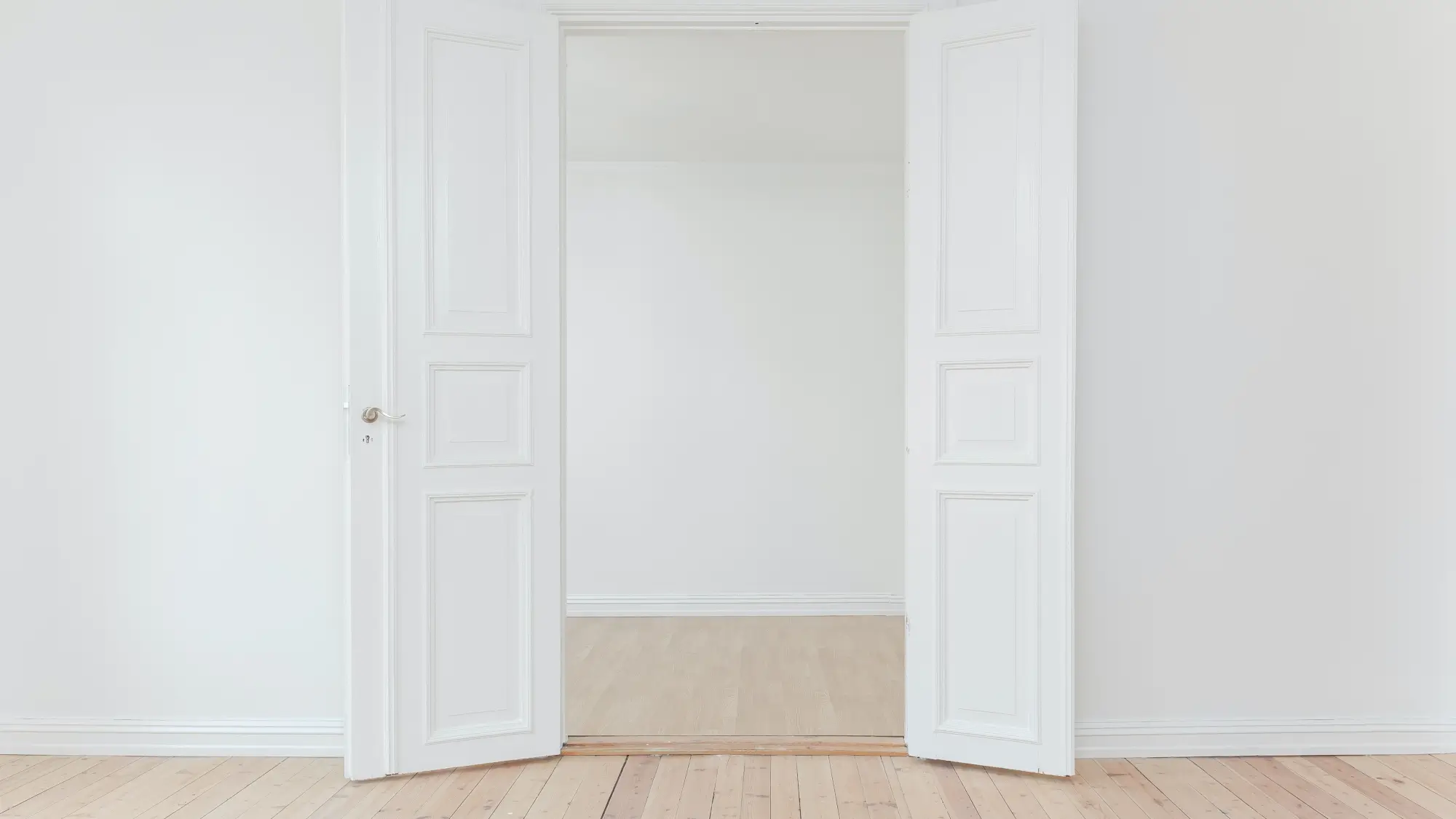 minimalist photography of open door in white room