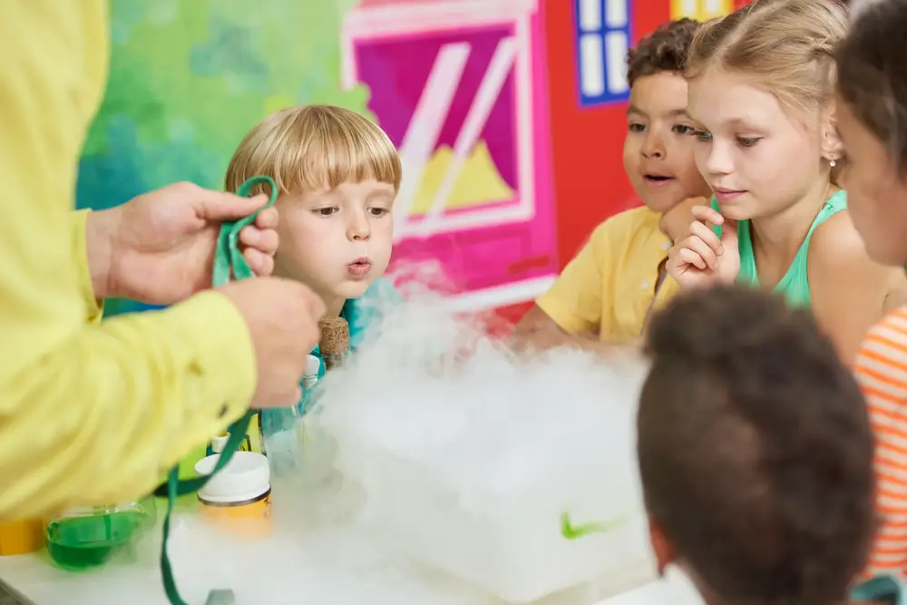 Experiment with dry ice for kids. Birthday party for kids steaming liquid. Concept of kids leisure.